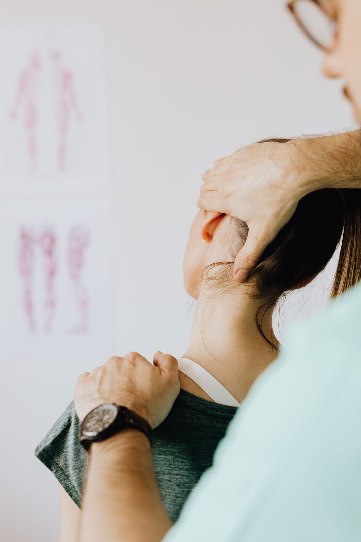 Ost&eacute;opathe posant d&eacute;licatement les mains sur la nuque d'un patient, technique tissulaire douce
